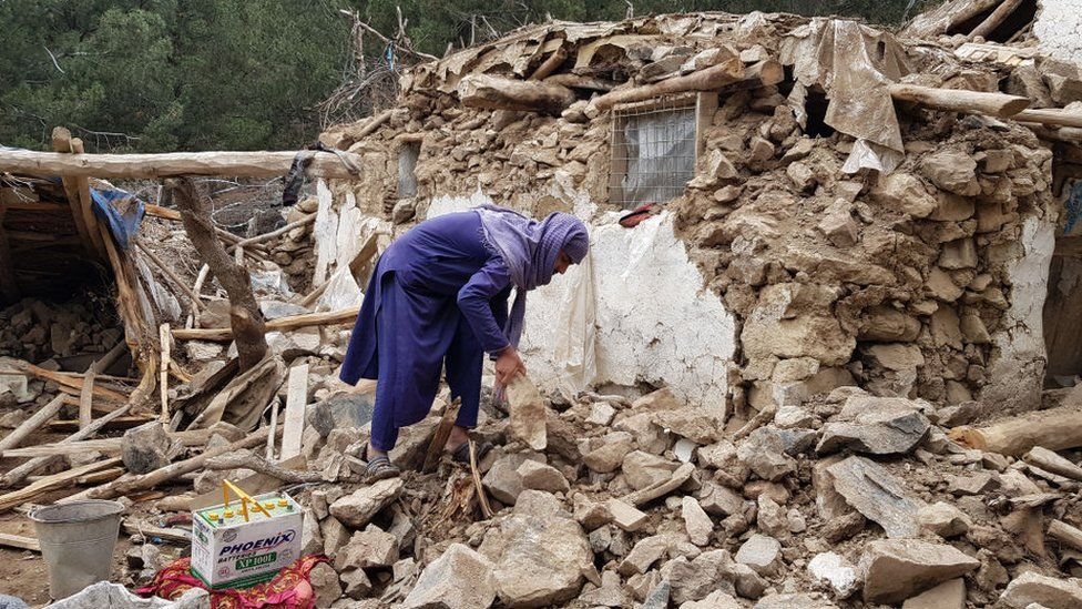 رجل يبحث عن متعلقاته تحت الأنقاض في أعقاب الزلزال