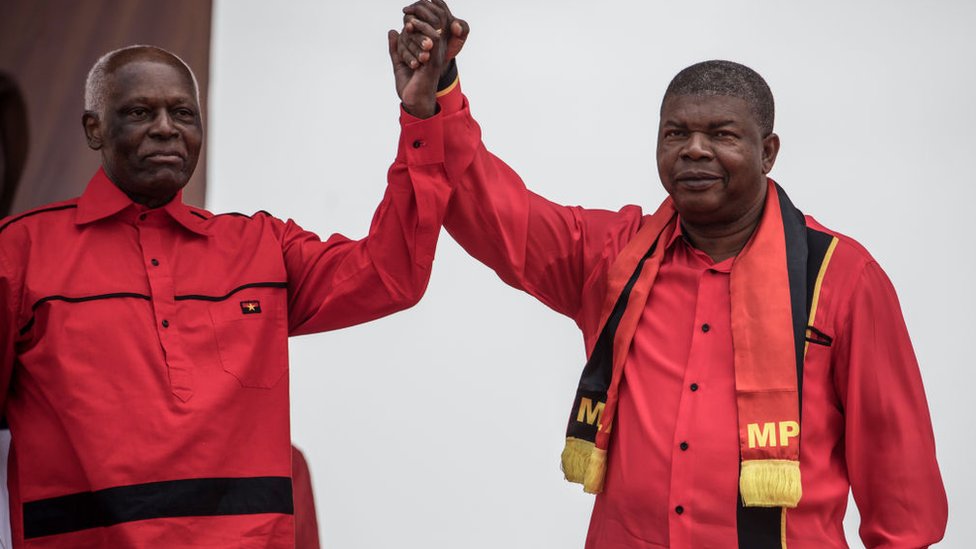 Президент Анголы и Народное движение за освобождение Анголы Президент Жозе Эдуарду душ Сантуш и кандидат в президенты от МПЛА Жоао Лоуренку держатся за руки во время заключительного митинга кампании в Луанде 19 августа 2017 года.