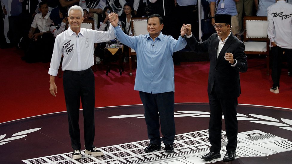 Ganjar Pranowo, Prabowo Subianto, Anies Baswedan hold hands as they attend a televised debate at the election commission headquarters in Jakarta, Indonesia, December 12, 2023.