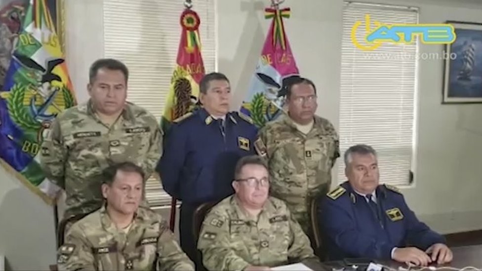 Кадр из рекламного видеоролика, выпущенного ATB, на котором главнокомандующий вооруженными силами Уильямс Калиман (C-снизу) выступает в телеобращении из Ла-Паса 10 ноября 2019 г.