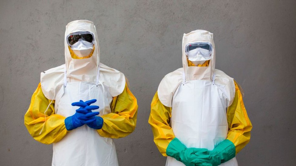 Dos hombres en preparativos contra el ébola en África.
