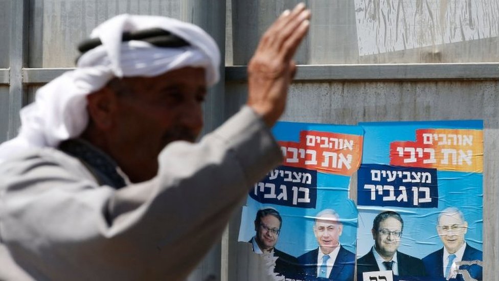 Палестинские жесты возле израильских предвыборных плакатов в Хевроне (09.07.19)