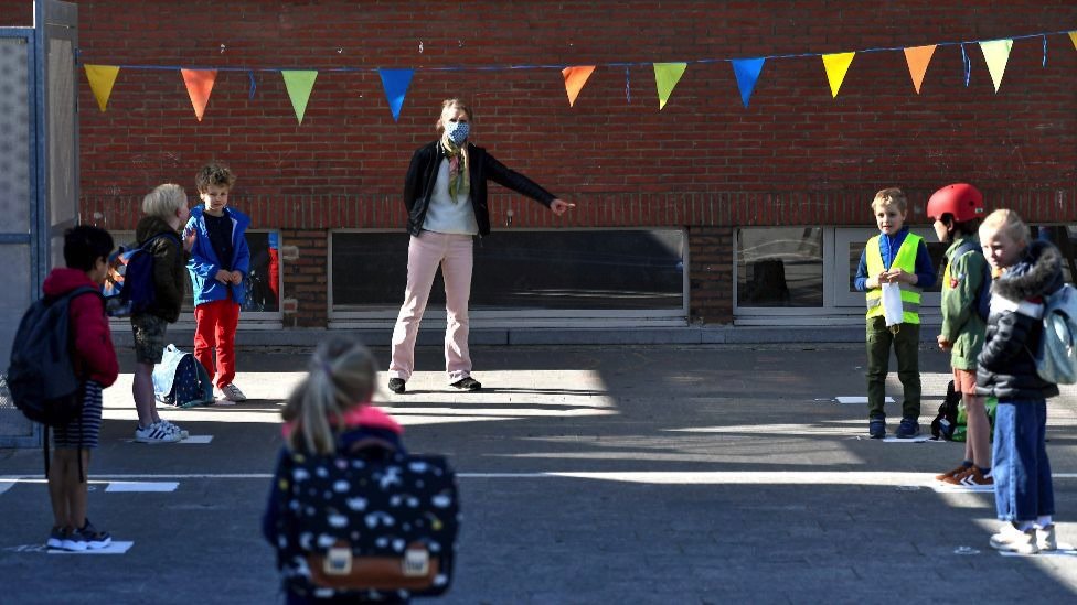 Crianças em distanciamento social no pártio da escola nos Países Baixos em 5 May 2020