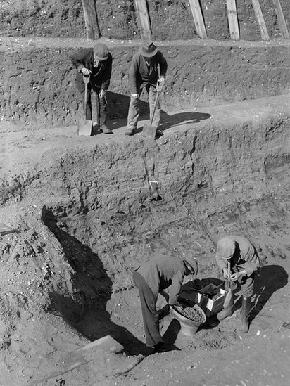 31 July 1939: Workmen sift through earth at the bottom of the excavation of the Anglo-Saxon burial ship at Sutton Hoo, Suffolk.
