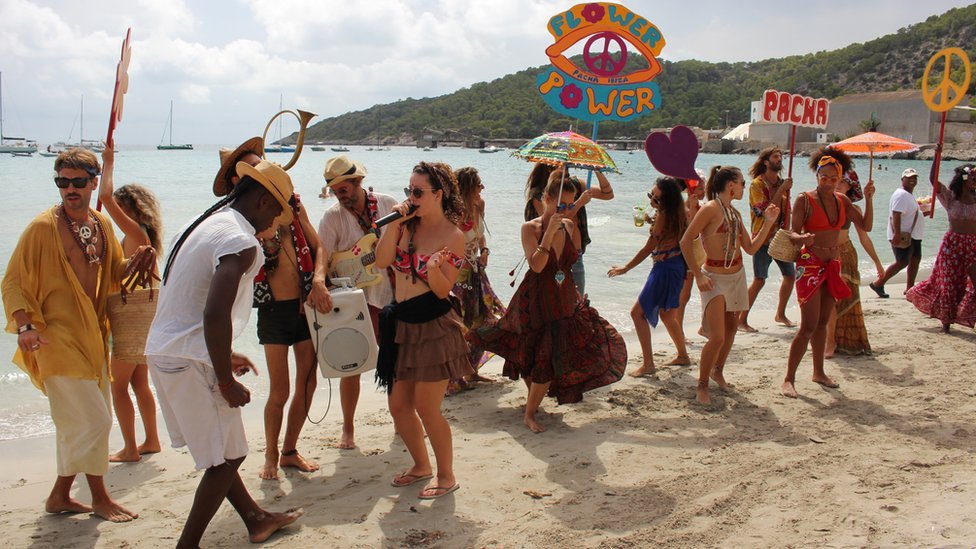 Gente bailando en un club de playa en Ibiza.
