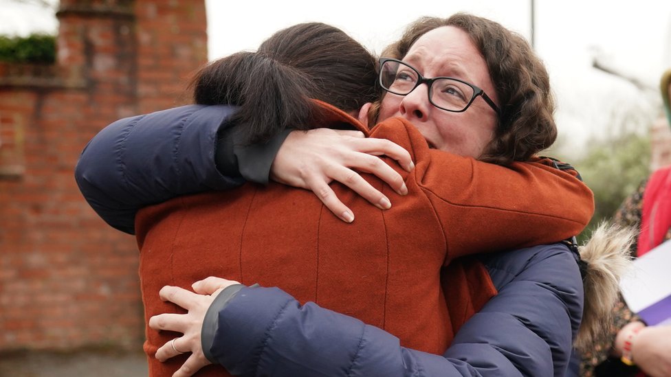 Rhiannon Davies (izquierda) abraza a Kayleigh Griffiths, luego de la publicación del informe final de Donna Ockenden