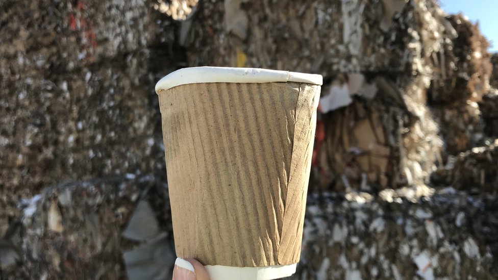 Crushed coffee cup and spilt coffee over financial newspaper Crushed coffee cup and spilt coffee over financial newspaper