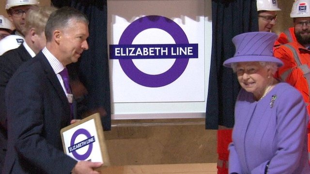 The Queen beside new logo for the line