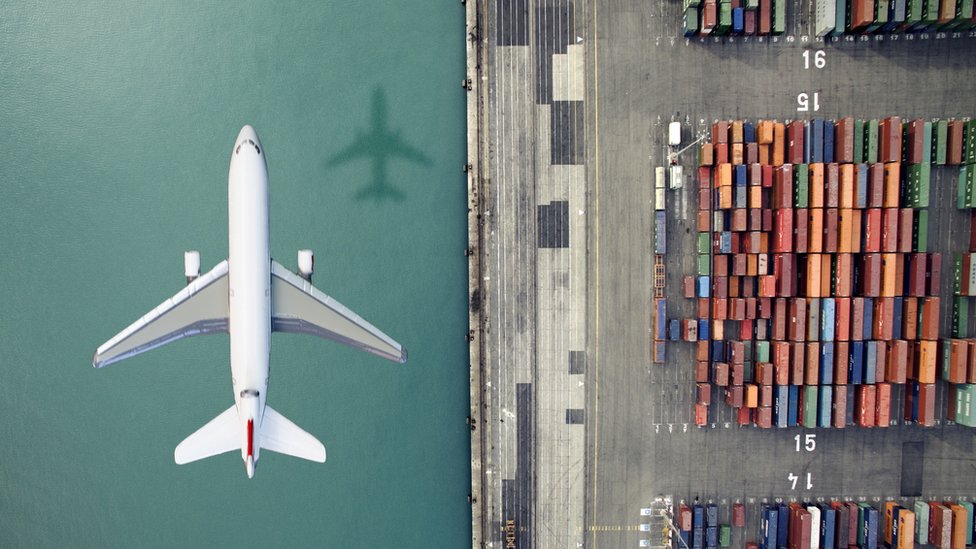 Los buques de carga emiten unas 1.000 millones de toneladas de CO2 anualmente, comparado con 781 millones de la industria de la aviación. Avión volando junto a un carguero