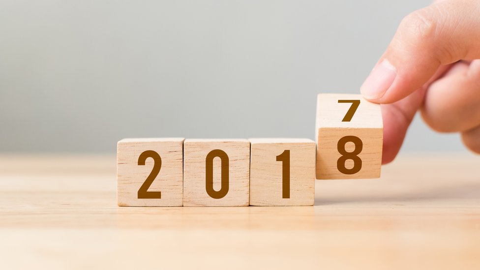 Algunos expertos coinciden en que el cambio de año no es necesariamente la mejor época para plantearse nuevos retos. Una mano le da la vuelta a un cubo de madera que representa el cambio de año.