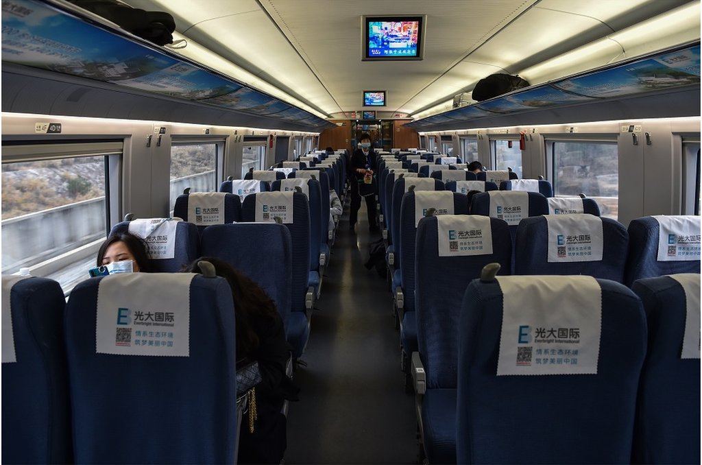 2020年1月23日，戴著防護口罩的乘客坐在上海至武漢的高鐵車廂內。