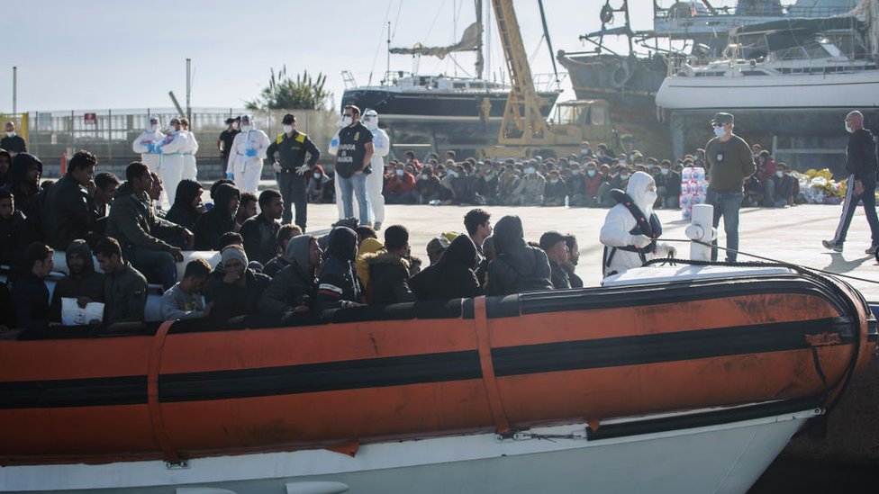 مهاجرون يصلون على متن زورق دورية في ميناء روتشيلا يونيكا، إيطاليا