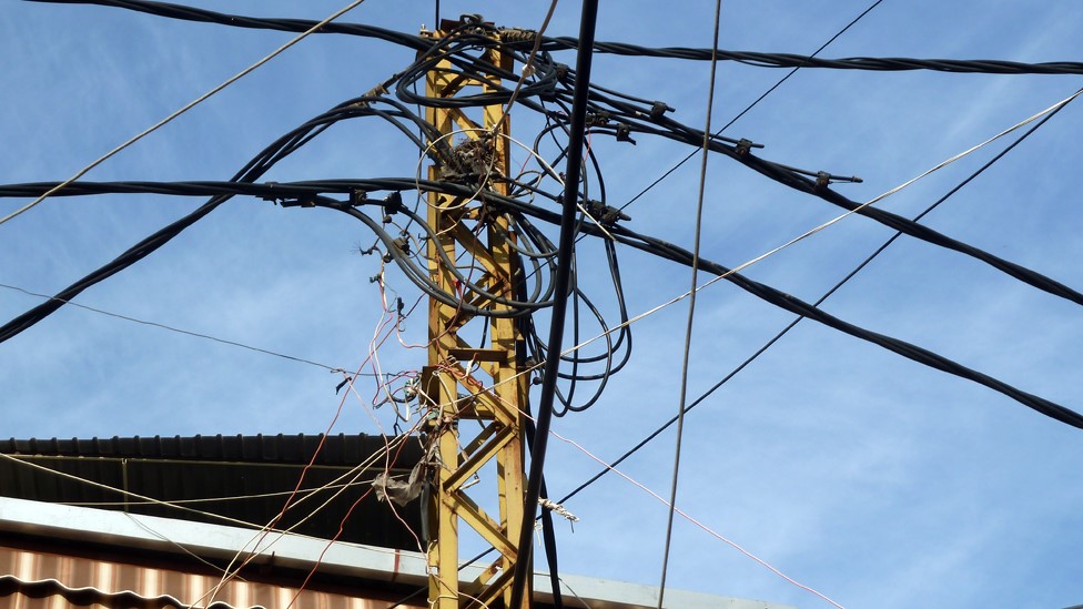 Электрические провода протянуты между зданиями в Ливане