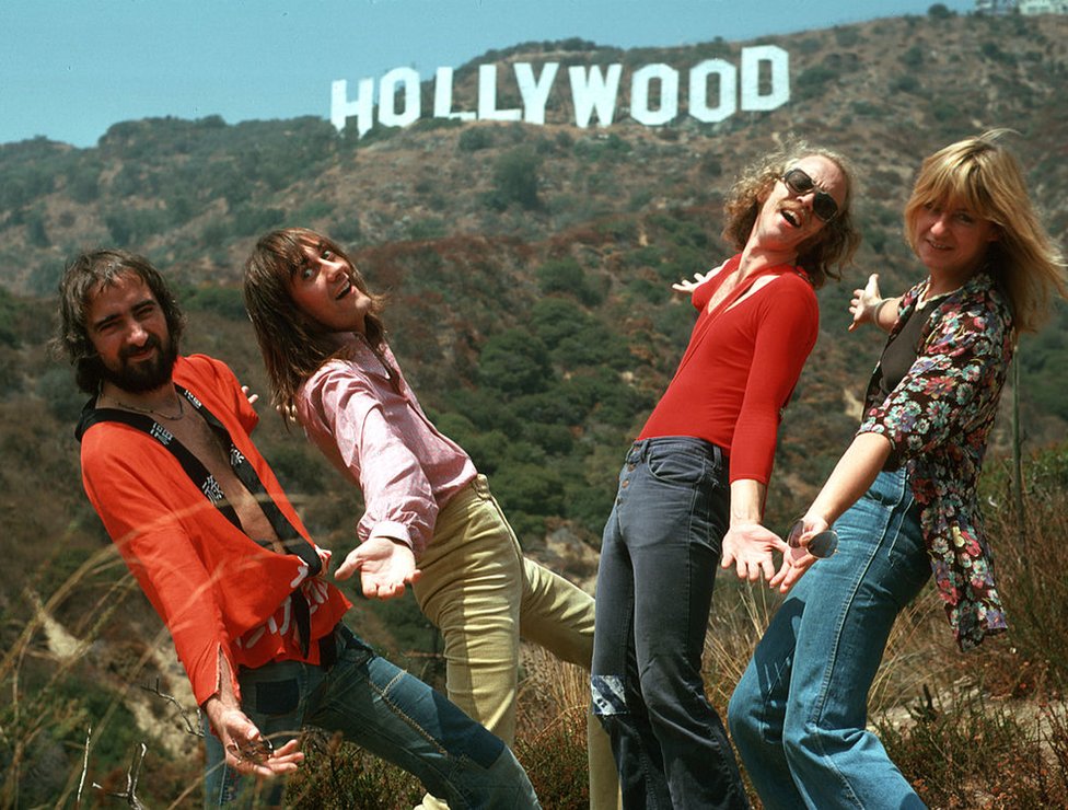 John McVie, Mick Fleetwood, Bob Welch y Christine McVie del grupo de rock Fleetwood Mac posan para un retrato ante el cartel de Hollywood en Los Ángeles, California, en 1974.
