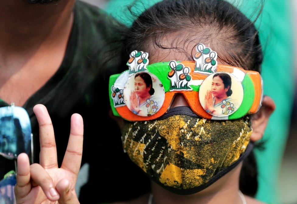 A Trinamool Congress party (TMC) supporter wears glasses with pictures of party supreemo Mamata Bannerjee and shows victory sign as they celebrate after winning an absolute majority in the West Bengal Assembly Election in Kolkata, India, 02 May 2021