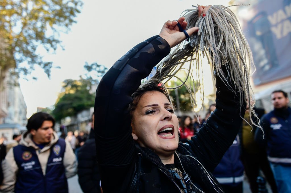 A woman cuts off her hair during a protest against the Iranian government in Istanbul, Turkey. October 2022.