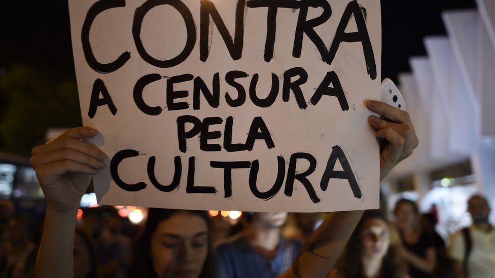 Демонстрант держит табличку« Против цензуры культуры », когда художники и музыканты собираются во Паласио дас Артес во время выставки художника« Сделай свою Сикстинскую капеллу » Педро Моралейда, Белу-Оризонти, Бразилия, 9 октября 2017 г.