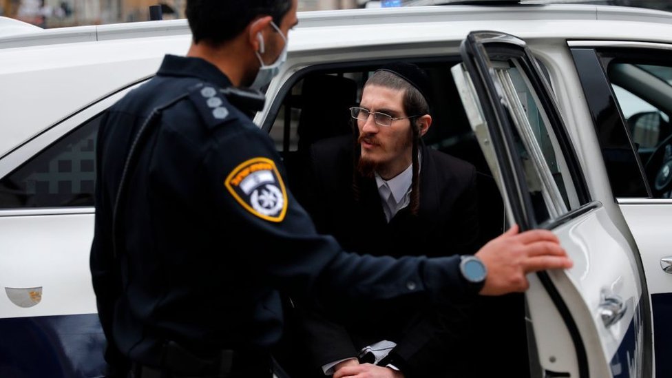 Un policía detiene a un ultraortodoxo en Me'a She'arim, Jerusalén.