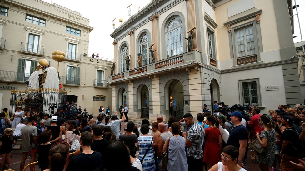 Люди стоят и смотрят перед Театром-музеем Дали во время эксгумации испанского художника Сальвадора Дали