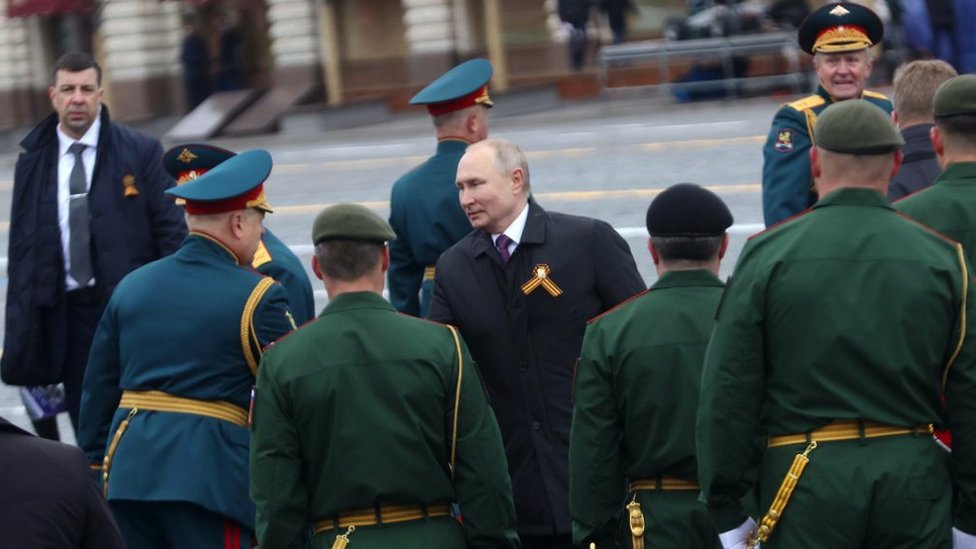 Russian President Vladimir Putin shakes hands with military officers during the Victory Day military parade in Moscow's Red Square on 9 May 2021