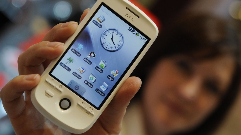 Женщина держит телефон HTC