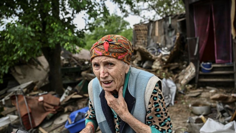 A woman outside her damaged house after it was hit by a missile in Bakhmut in Donbas on 22 May