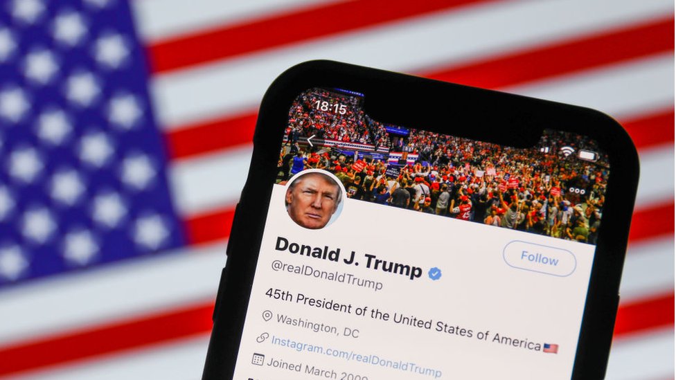 Иллюстрация к ленте Трампа в Твиттере на фоне американского флага