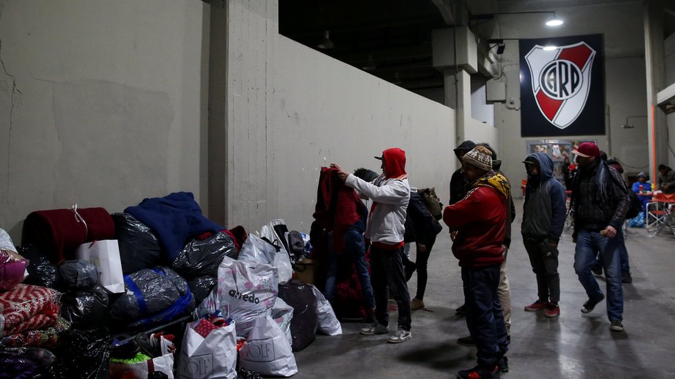Бездомные просматривают сумки с подаренной одеждой на стадионе Ривер Плейт в Буэнос-Айресе, Аргентина, 3 июля 2019 г.