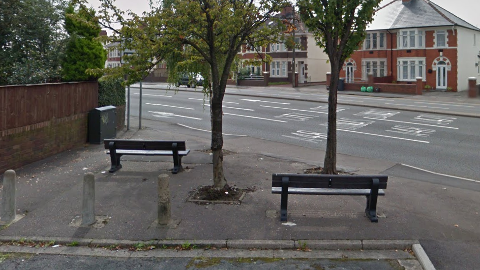 Две скамейки с видом на оживленную дорогу в Кардиффе.