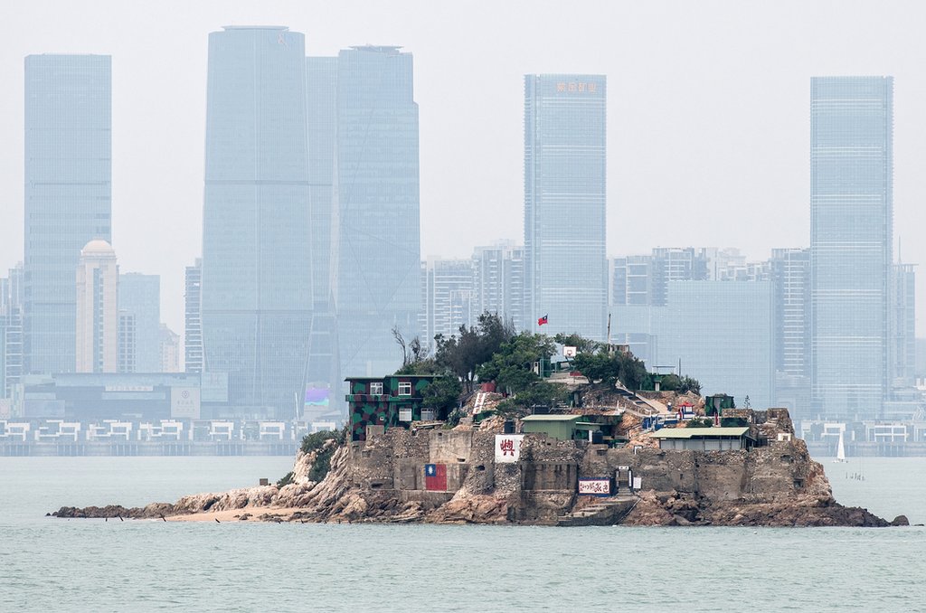 台灣金門離島小島——獅嶼。島上插有中華民國青天白日旗，對面高樓大廈是福建廈門市（2018年4月20日資料照片）。