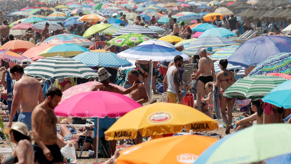 Заполненный пляж Мальварроса в жаркий день в Валенсии, Испания
