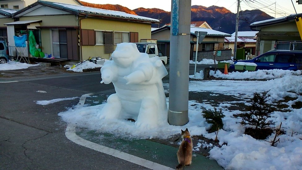 Снежное творение пользователя Instagram kazu.sae - персонаж Pokemon Kamex на автостоянке.