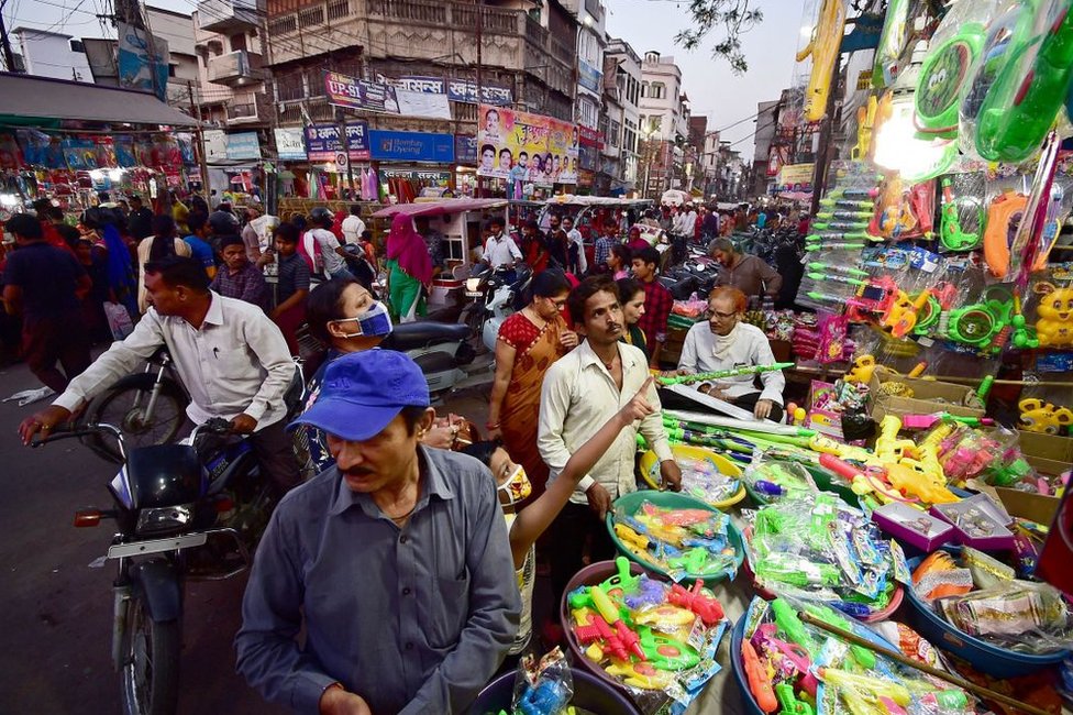 People crowd at a roadside shop to buy water pistols used in the upcoming Holi celebrations, which is a popular Hindu spring festival of colours in Allahabad on March 27, 2021.