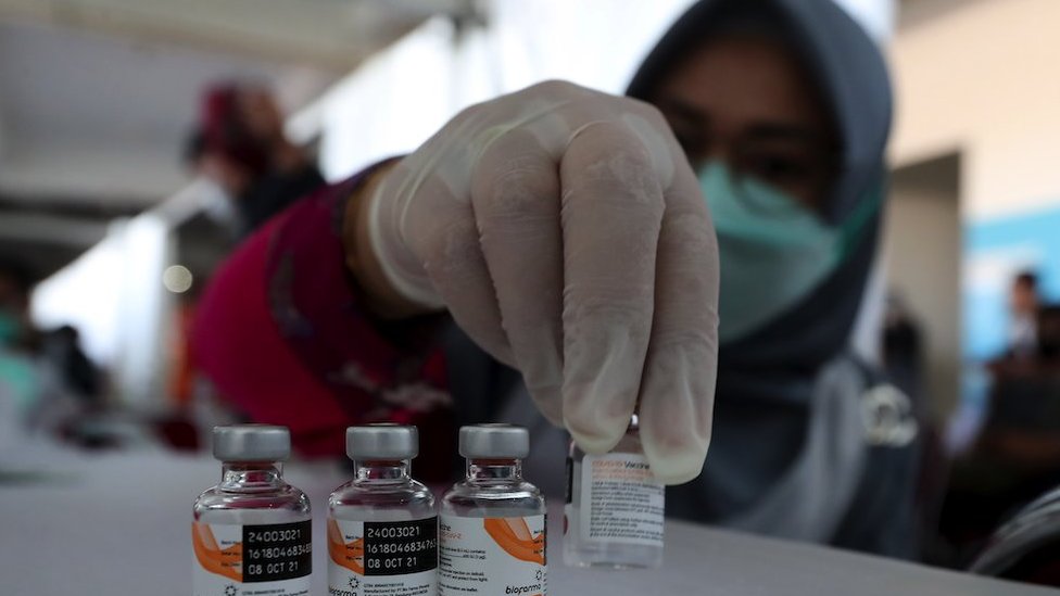 An Indonesian health worker shows vials containing the Sinovac COVID-19 vaccine made by Biofarma during a COVID-19 vaccination drive at Pakansari Stadium in Bogor, West Java, Indonesia, 22 June 2021.