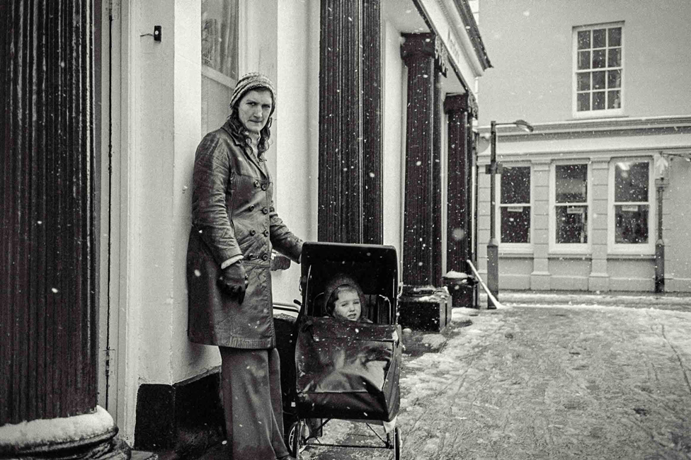 Человек с ребенком в коляске на улице, в Конви
