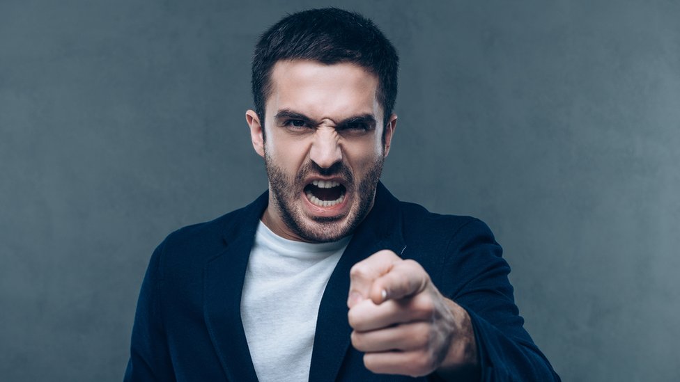 Las personas bajitas no son más agresivas ni tienen peor genio que las altas, a pesar de la creencia. Hombre enfadado apuntando con el dedo