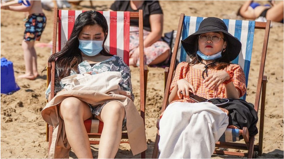 People on the beach with facemasks