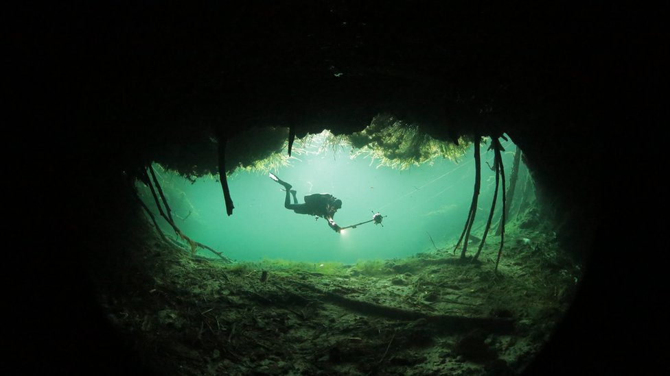 Buzo nadando en una cueva