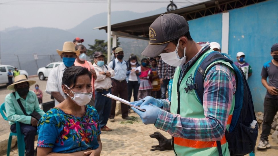 Люди ждут в очереди, чтобы получить гуманитарную помощь от муниципалитета после введенных правительством ограничительных мер для предотвращения распространения коронавируса в Эль-Хато, Антигуа-Гватемала, Гватемала, 25 апреля 2020 года.