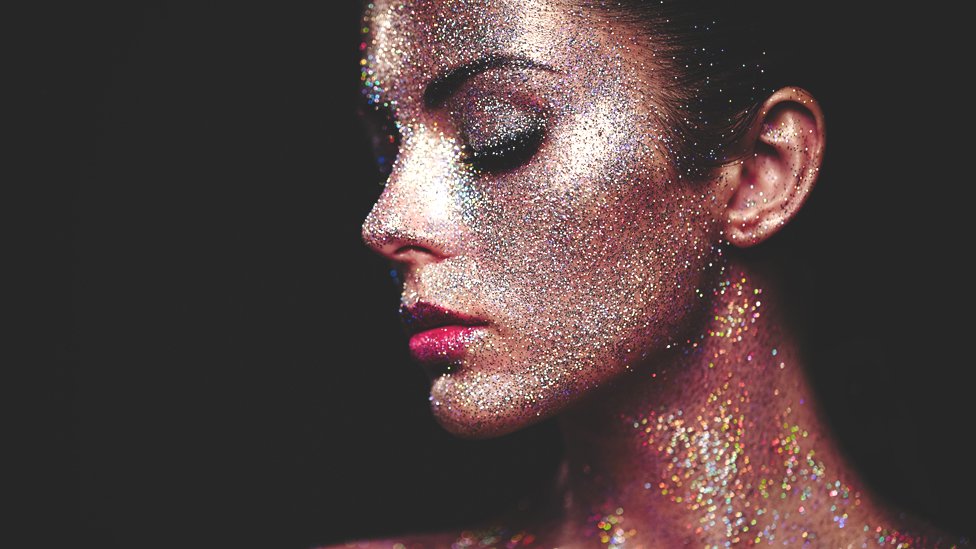 El uso de la purpurina para la piel está extendido. Mujer cubierta con purpurina