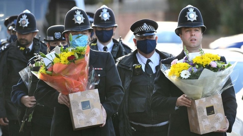 Police officers holding flowers