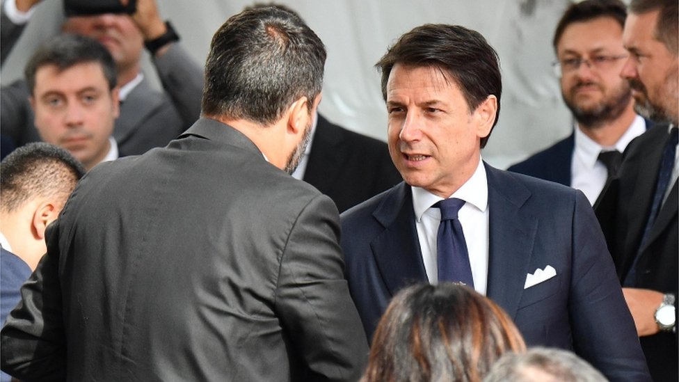 Giuseppe Conte, el independiente que lidera el gobierno de coalición entre la Liga Norte y el Movimiento Cinco Estrellas, saluda a Salvini durante un acto público.