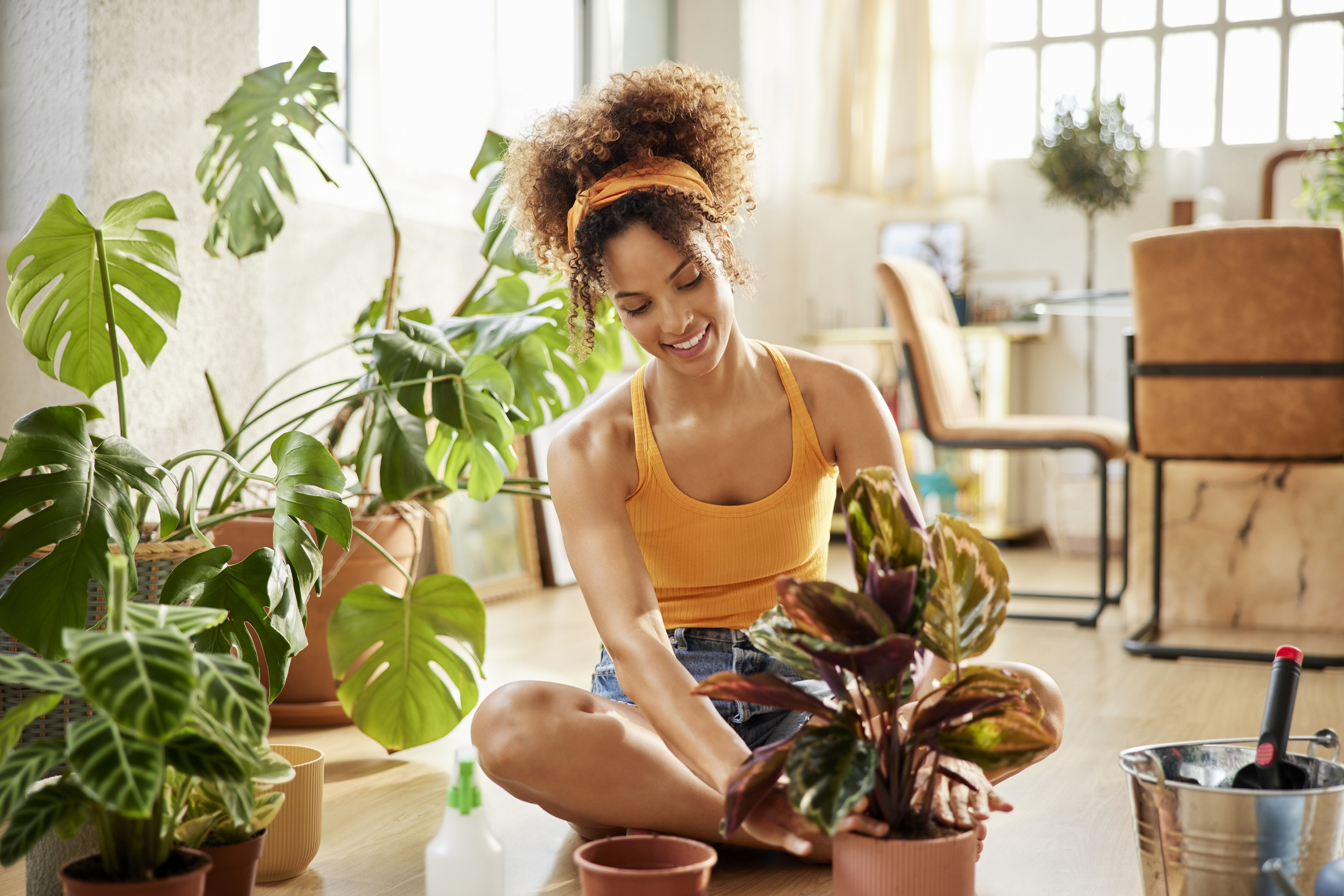 Mujer en su casa cuidando plantas.
