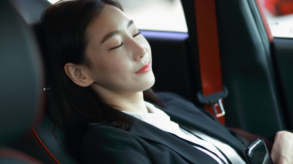 Mujer dormida placenteramente dentro de un vehículo.