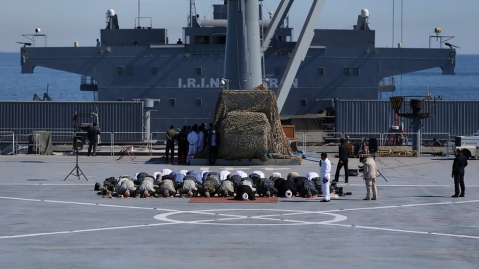 قادة عسكريون إيرانيون يؤدون الصلاة على متن سفينة حربية إيرانية الصنع قبل بدء مناورات في مياه خليج عمان.