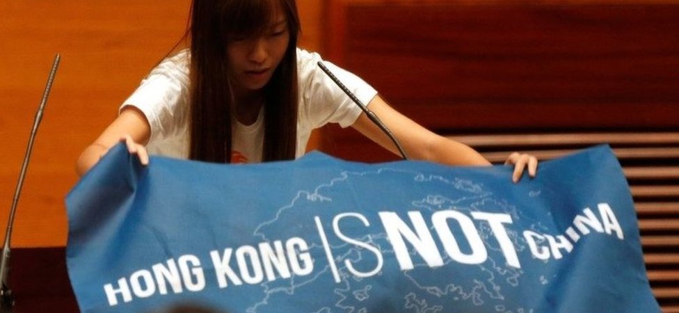 Новоизбранный депутат Яу Вай-цзин вывешивает баннер перед принятием присяги в Законодательном совете Гонконга, Китай, 12 октября 2016 года.