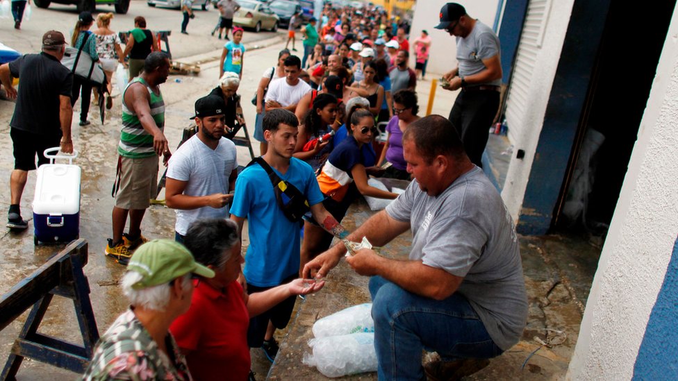 Se estima que la reposición de los servicios básicos en Puerto Rico demorará alrededor de ocho meses. Filas de gente buscando agua
