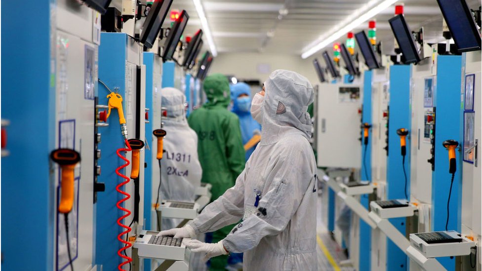 Employees work on the production line of silicon wafer at a factory of GalaxyCore Inc. on May 25, 2021 in Jiashan County, Jiaxing City, Zhejiang Province of China.
