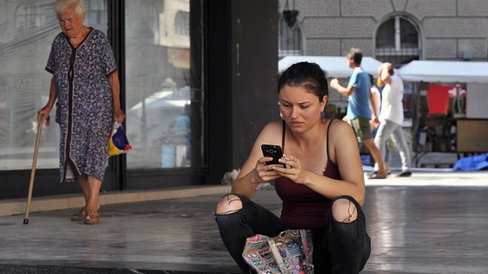 žena drži telefon u Beogradu