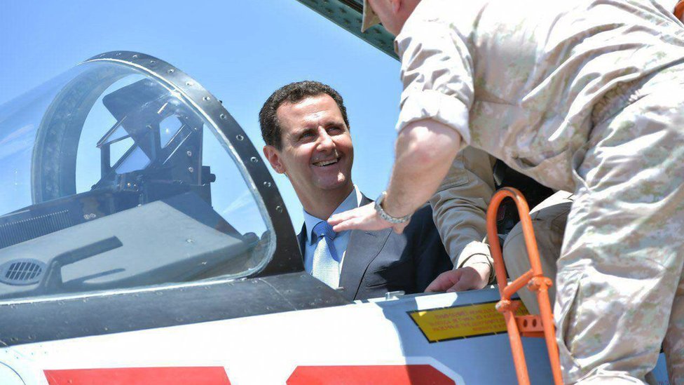 Президент Башар Асад сидит в самолете Су-27 во время посещения военной базы Хмаймим в провинции Латакия, Сирия (27 июня 2017 г.)